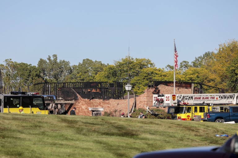Emergency services respond to a shooting and fire at the Church of Jesus Christ of Latter-day Saints in Grand Blanc, Michigan. The church is half burnt.