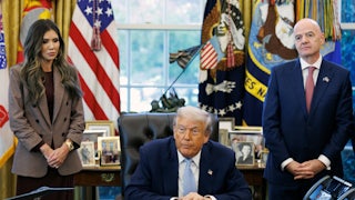 Homeland Security Secretary Kristi Noem and FIFA President Gianni Infantino stand on either side of Donald Trump, who is seated at his desk in the Oval Office of the White House.