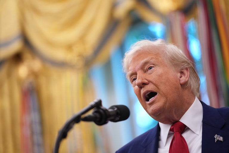 Donald Trump speaks into a microphone in the Oval Office