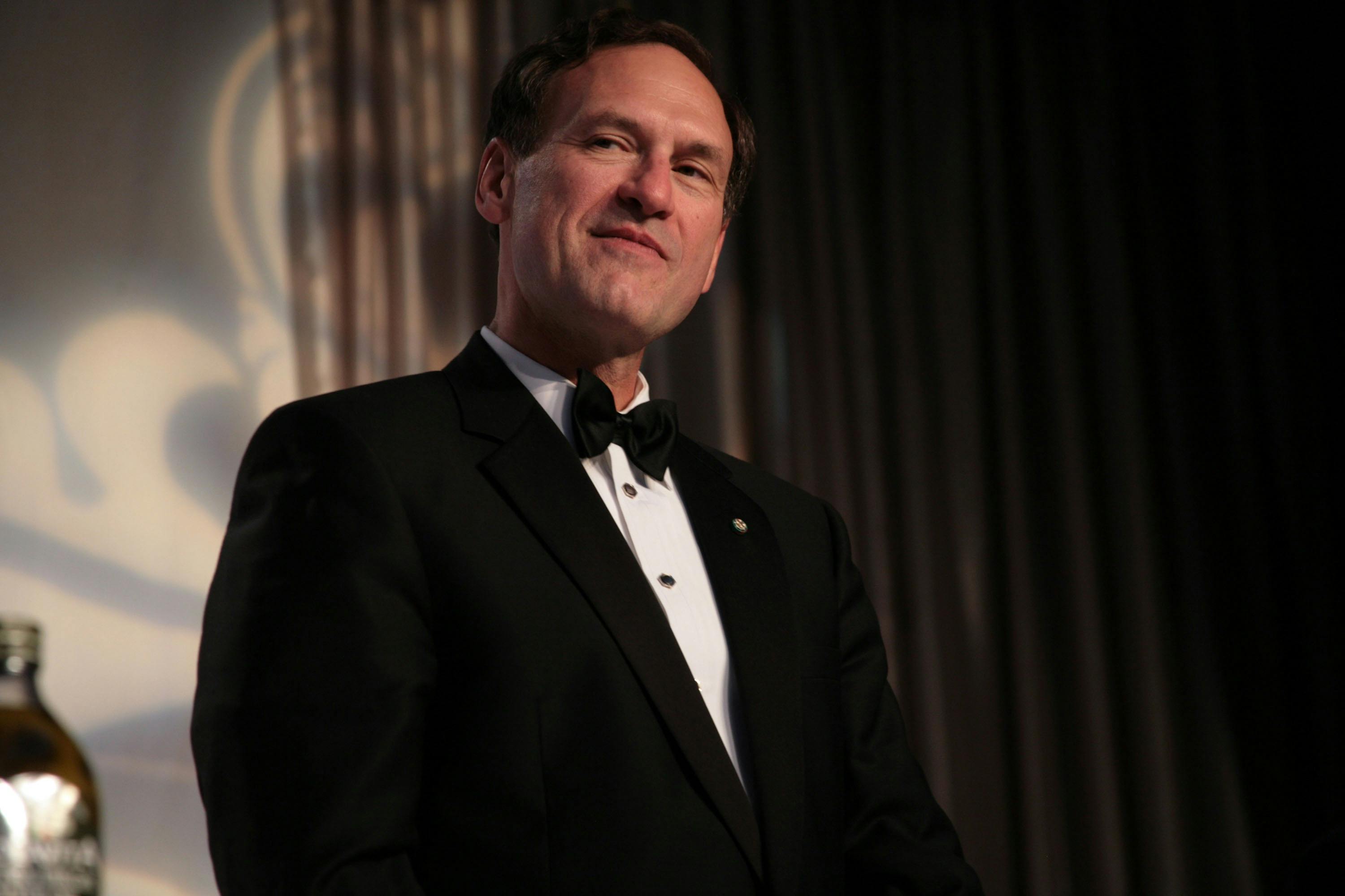 A tuxedo-clad Samuel Alito smirks.