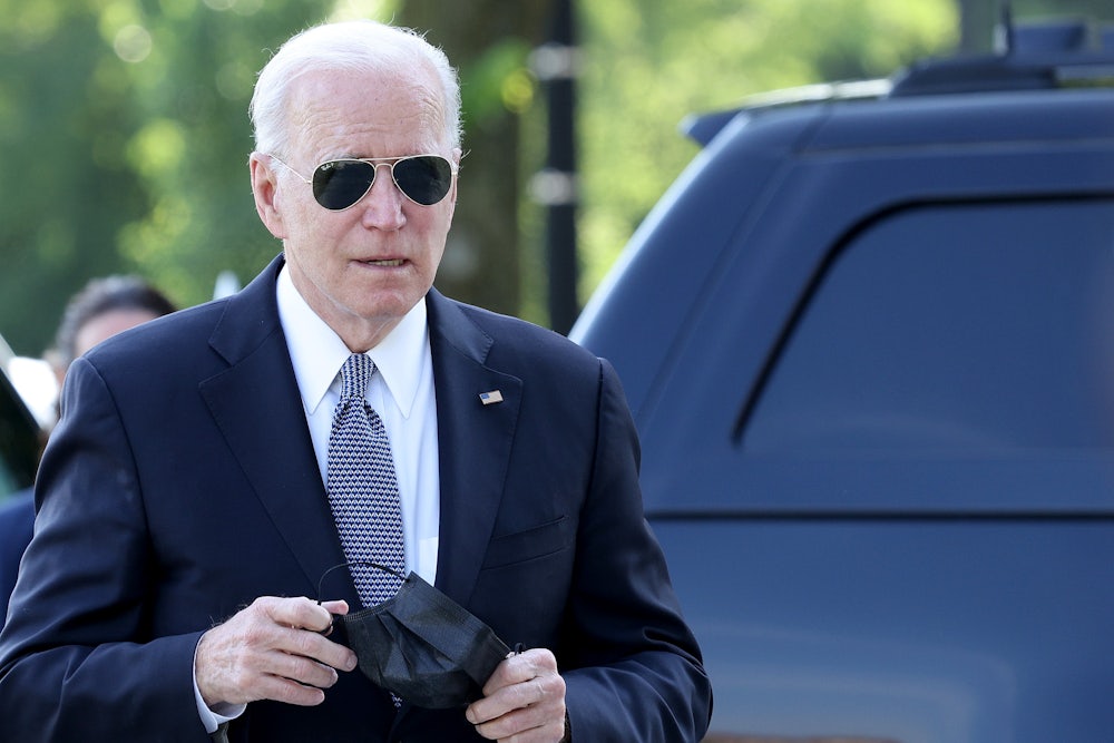President Joe Biden removes his mask as he strolls to the White House.