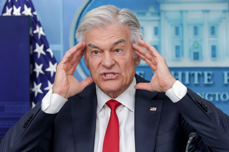 Dr. Mehmet Oz puts his fingertips on his temples while speaking during a White House press briefing