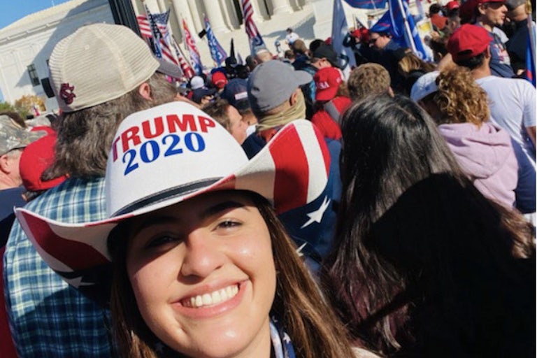 Barbara Balmaseda smiling in a crowd with a Trump 2020 hat