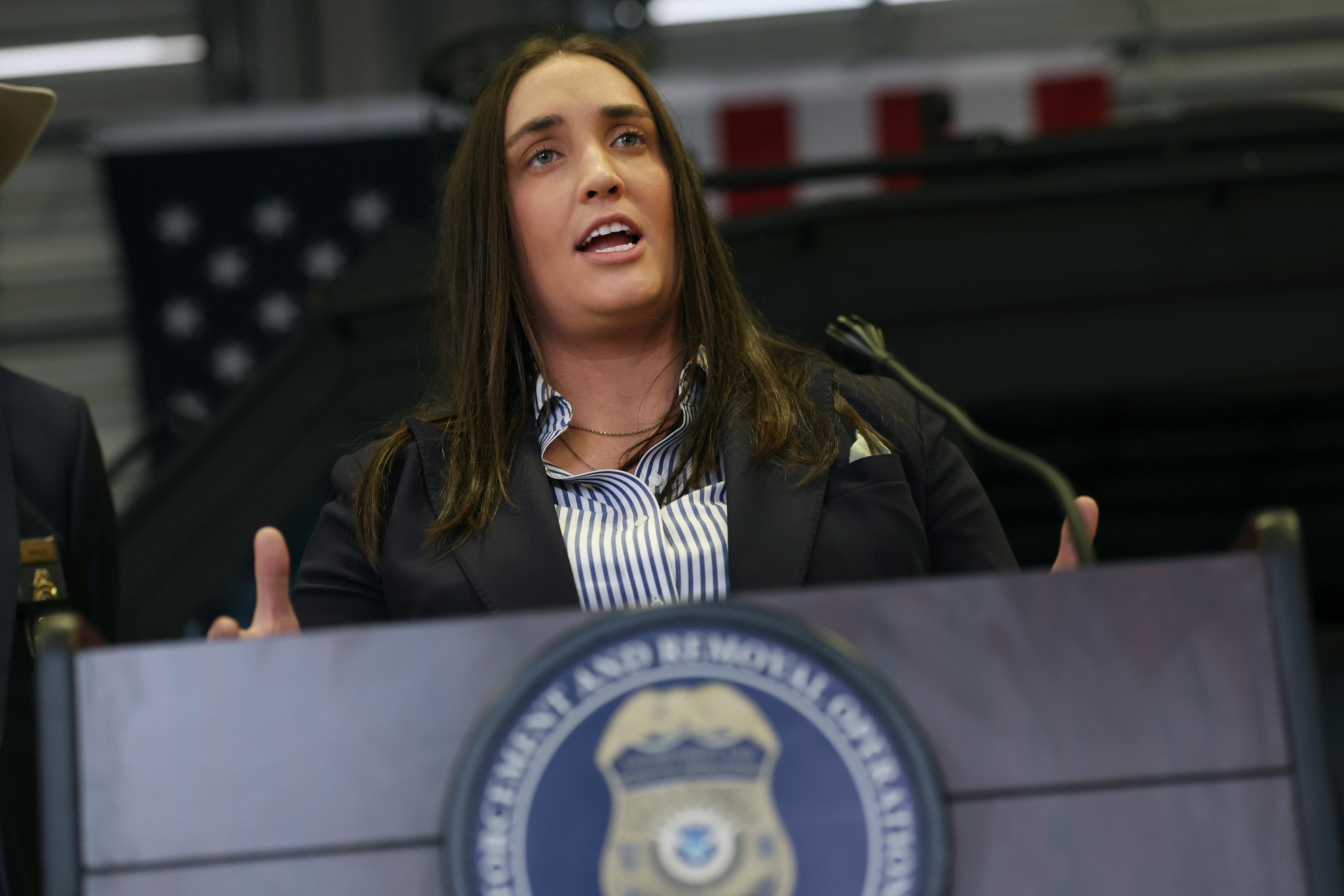 Former Deputy ICE Director Madison Sheahan gestures and speaks at a podium