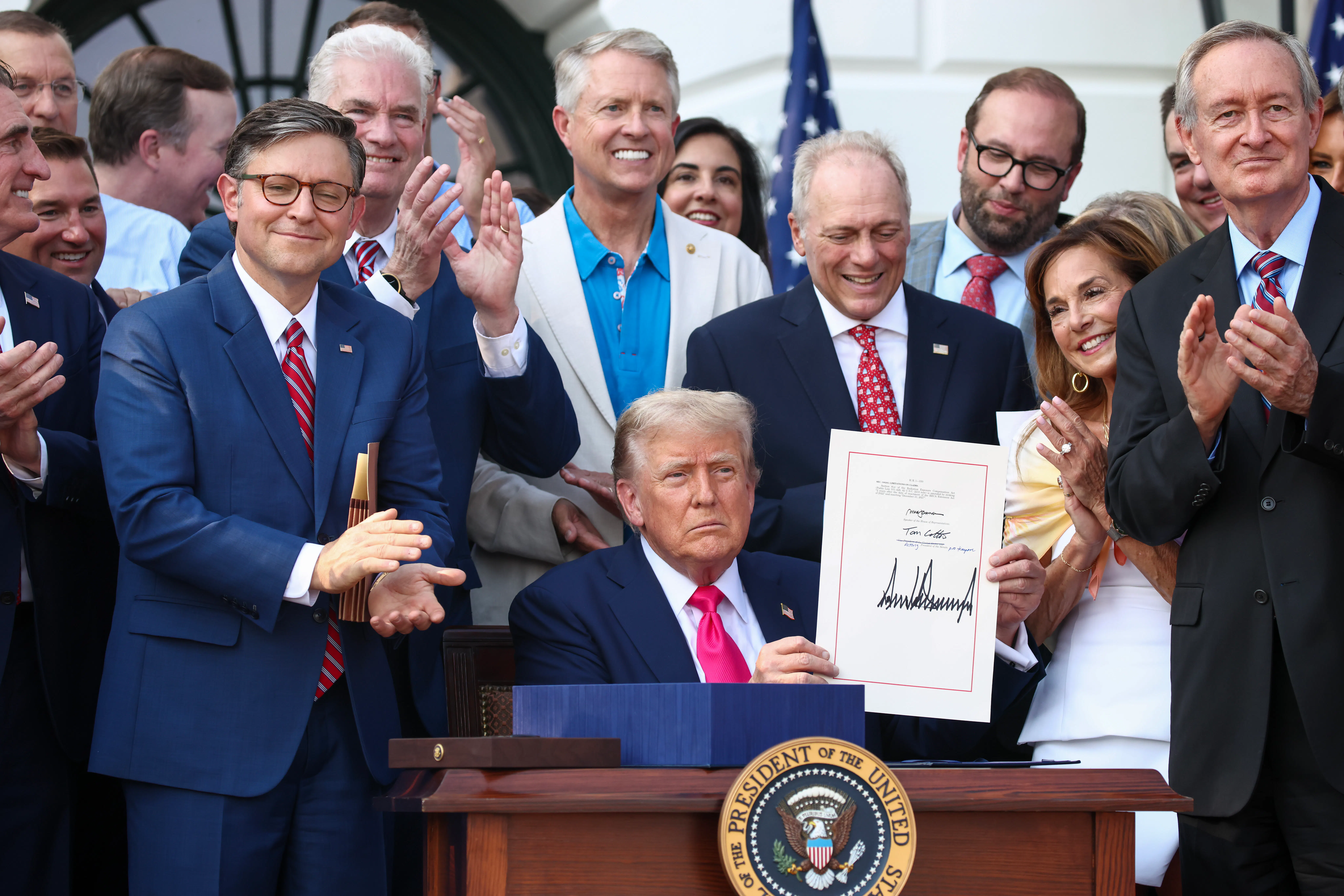 Donald Trump, joined by Republican lawmakers, signs the One Big Beautiful Bill Act into law on July 4, 2025.