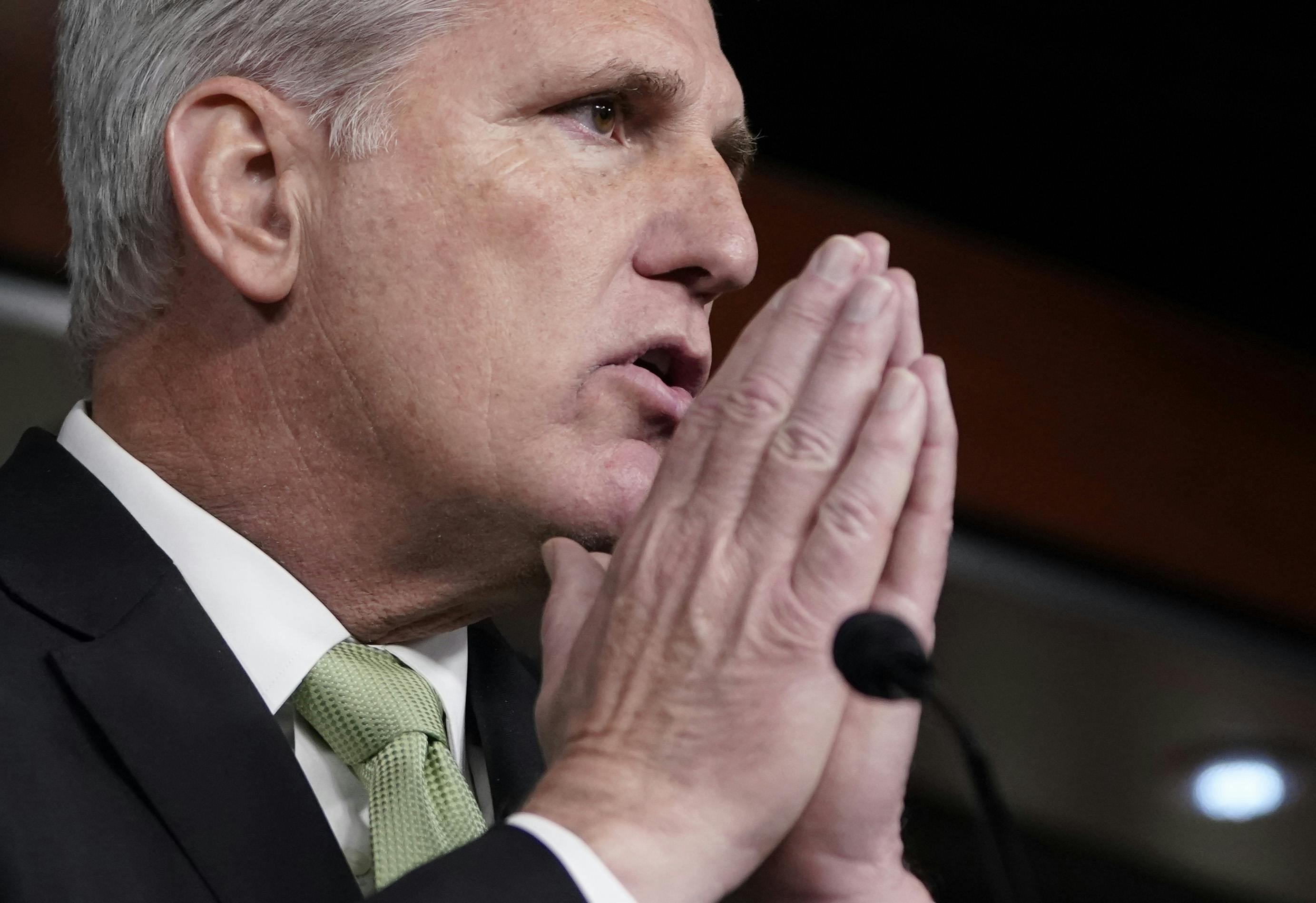 Kevin McCarthy puts his hands together in front of a podium.