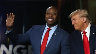 Senator Tim Scott waves and smiles as Donald Trump also smiles.