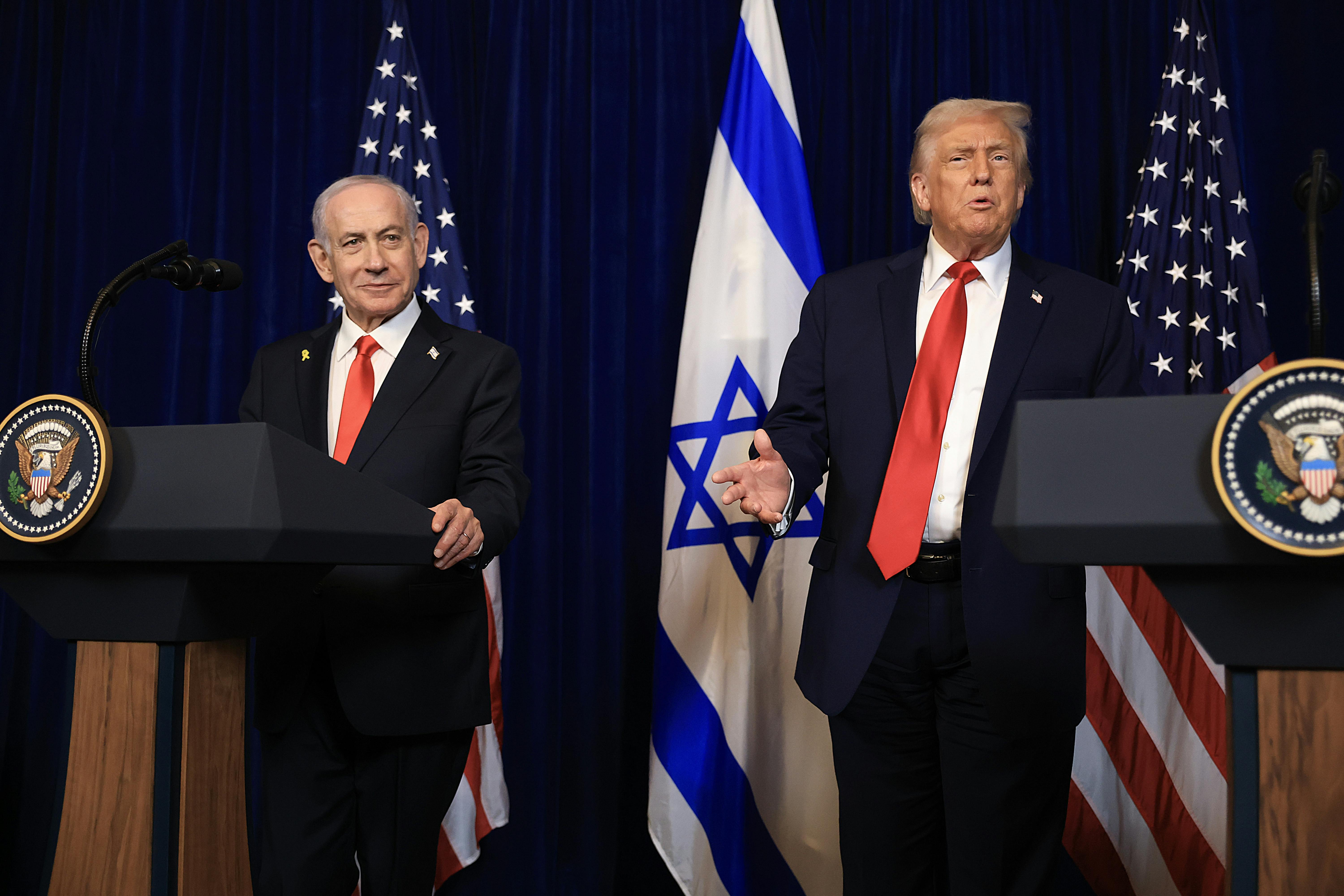 Israeli Prime Minister Benjamin Netanyahu and Donald Trump stand next to each other at podiums. Trump gestures and speaks.