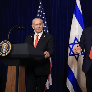 Israeli Prime Minister Benjamin Netanyahu and Donald Trump stand next to each other at podiums. Trump gestures and speaks.