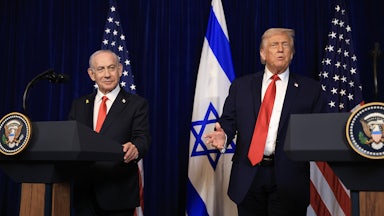 Israeli Prime Minister Benjamin Netanyahu and Donald Trump stand next to each other at podiums. Trump gestures and speaks.