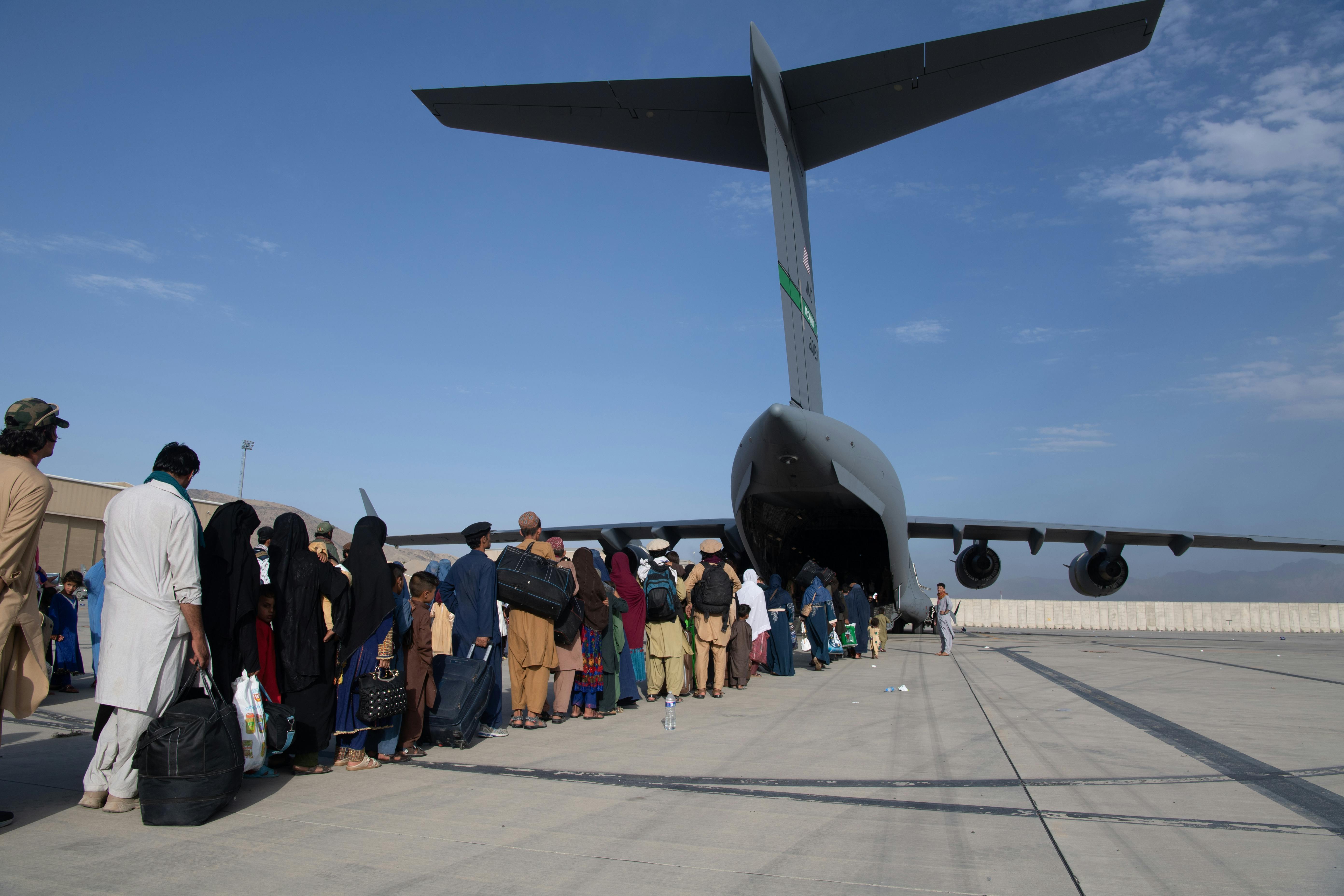 U.S. Air Force personnel load passengers aboard a U.S. Air Force C-17 Globemaster III in support of the Afghanistan evacuation in Kabul, Afghanistan in August of 2021. 