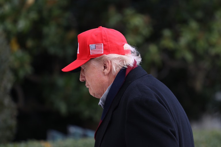 Donald Trump looks down while walking outside the White House