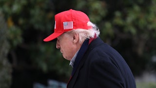 Donald Trump looks down while walking outside the White House