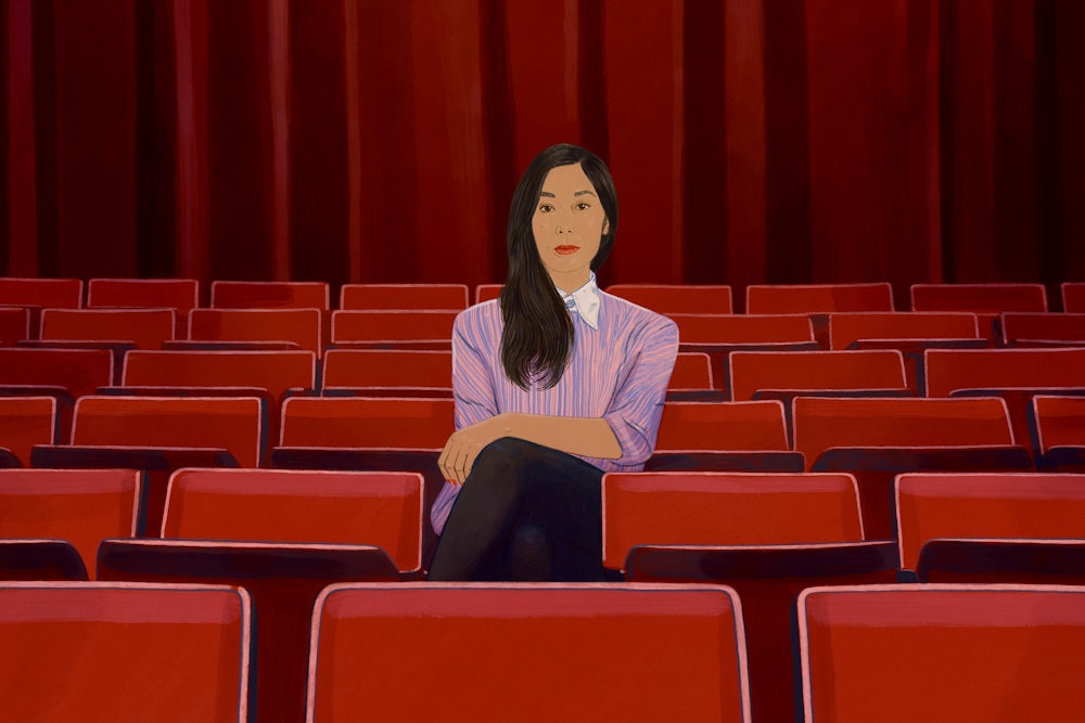 An illustration of author Katie Kitamura sitting in a row of empty theater seats, indicating that she's directing the action in the novel that's taking place on stage