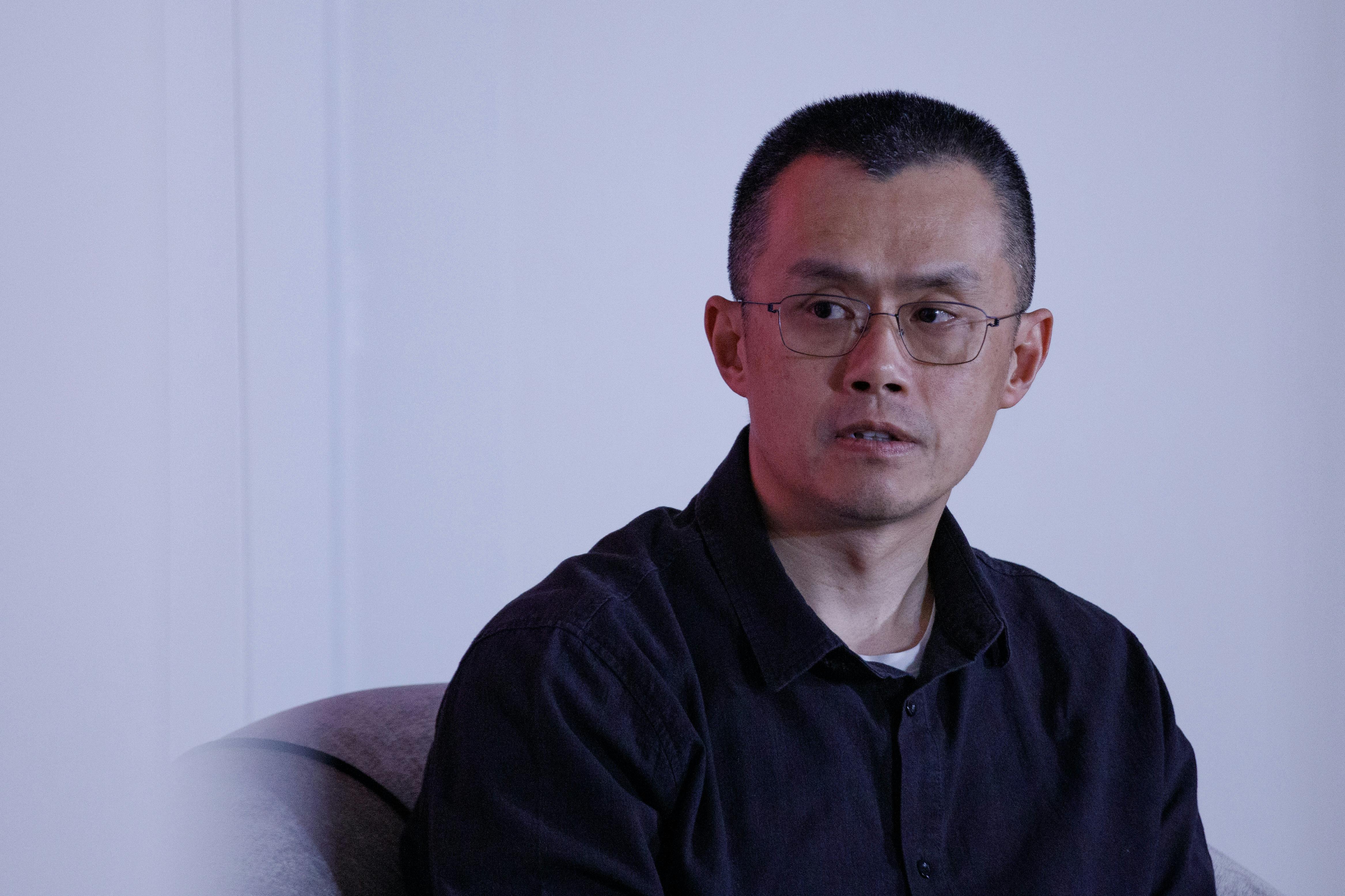 Binance founder Changpeng Zhao sits during an event