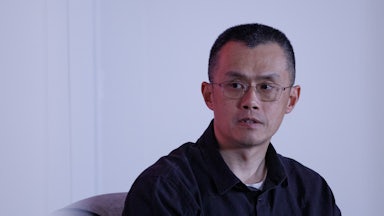 Binance founder Changpeng Zhao sits during an event