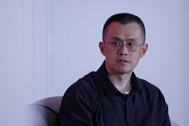 Binance founder Changpeng Zhao sits during an event