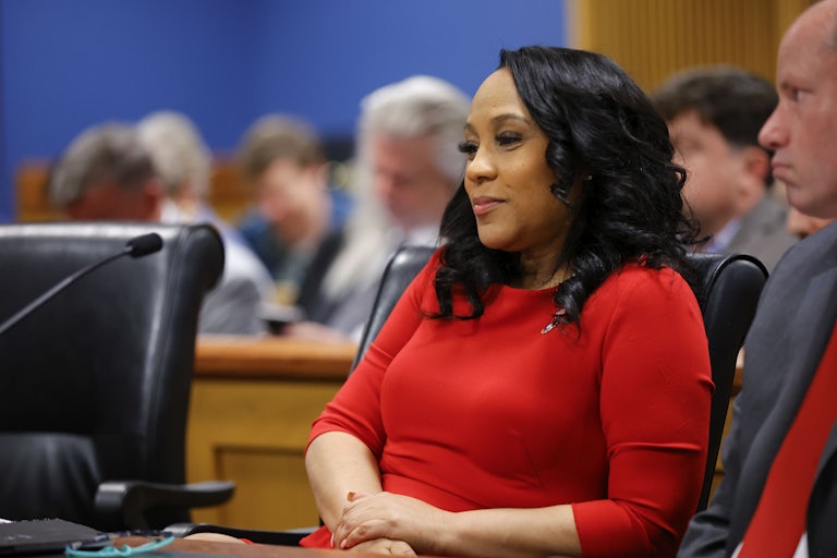 Fani Willis smiles while sitting in a chair