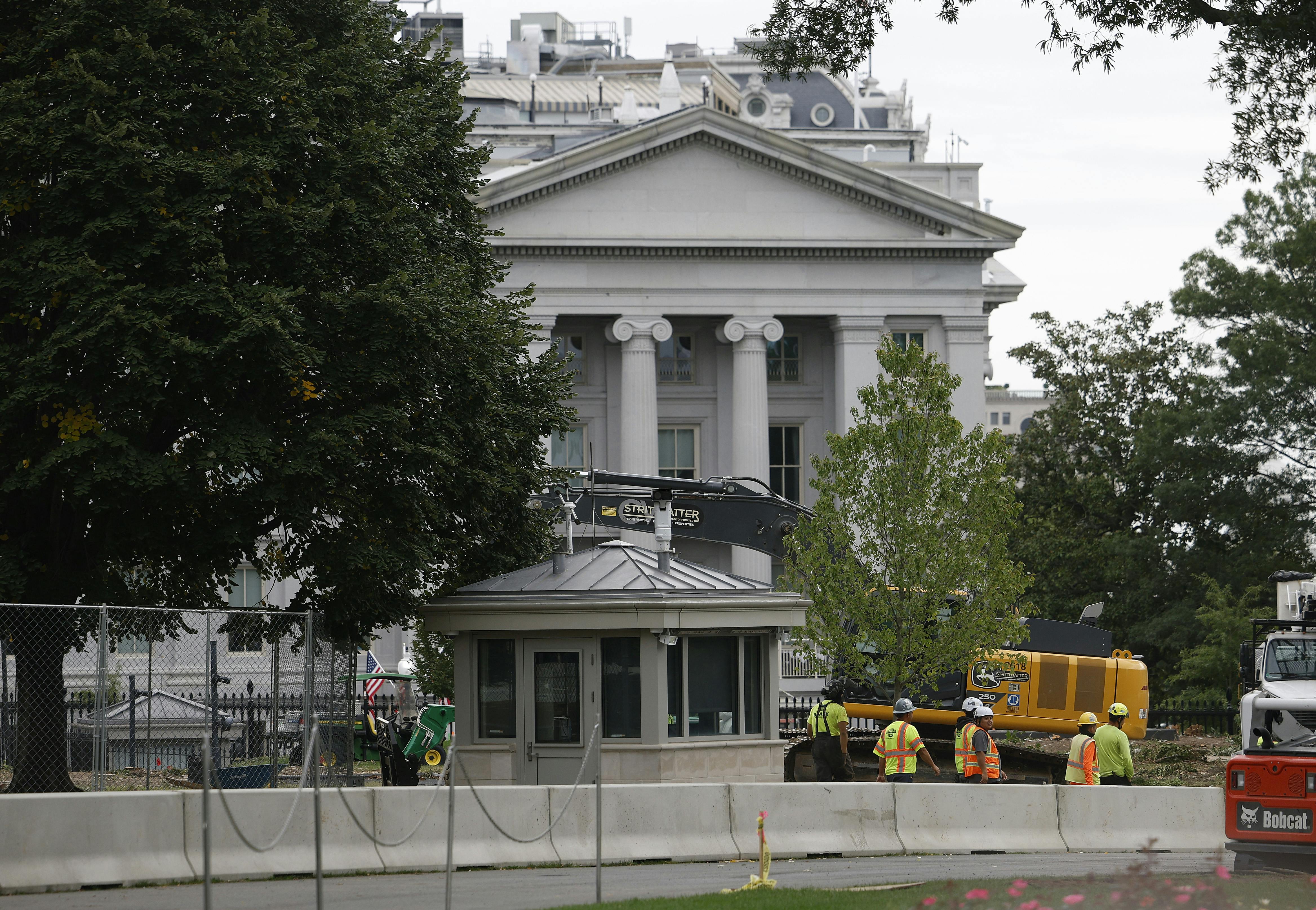 Construction workers stand outside the White House.