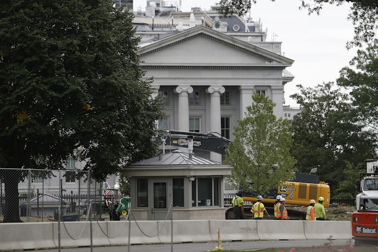 Construction workers stand outside the White House.