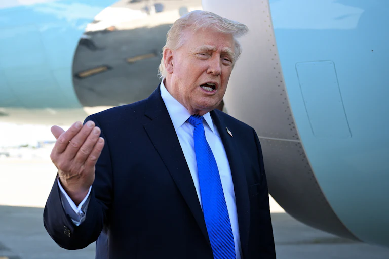 President Donald Trump speaks outside a plane