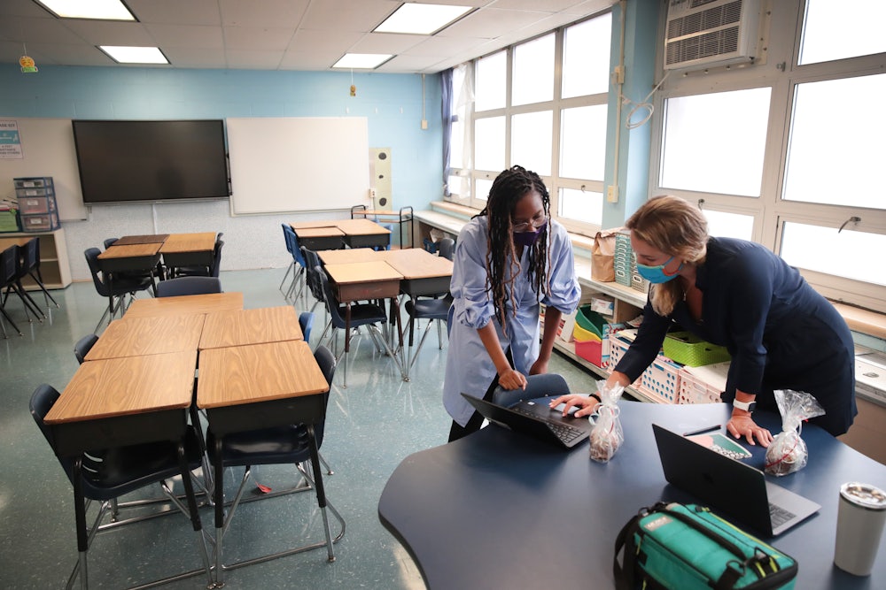 teachers with laptops in an empty Chicago classroom
