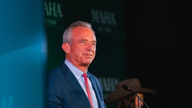Robert F. Kennedy Jr. stands at a lectern in front of a MAHA backdrop.