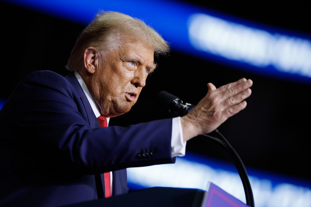 Donald Trump speaks at a lectern and makes a hand gesture for emphasis