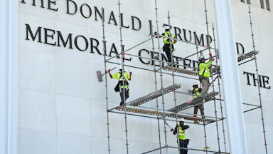 Workers remove Donald Trump’s name from the Kennedy Center on June 12.
