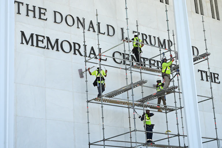 Workers remove Donald Trump’s name from the Kennedy Center on June 12.