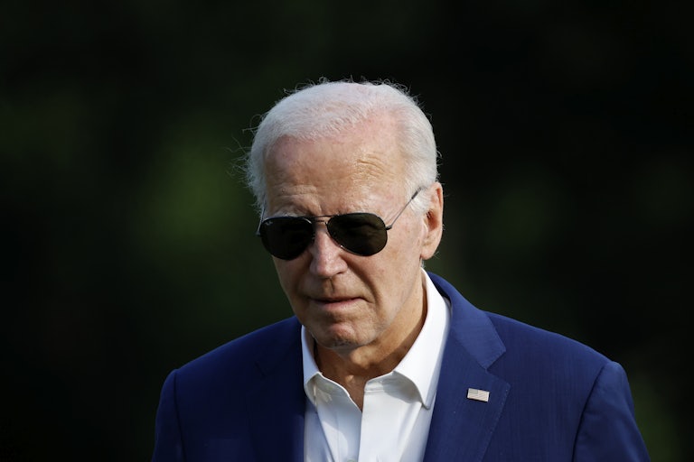Joe Biden wears sunglasses while looking down