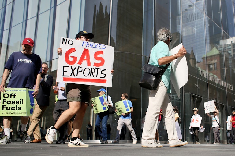Protesters hold signs reading "No Fracked Gas Exports" and "Off Fossil Fuels."