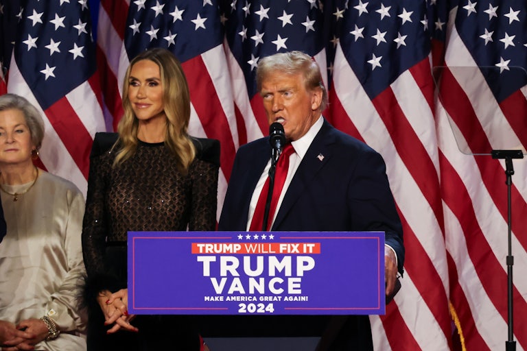Donald Trump looks to the side while speaking at a podium