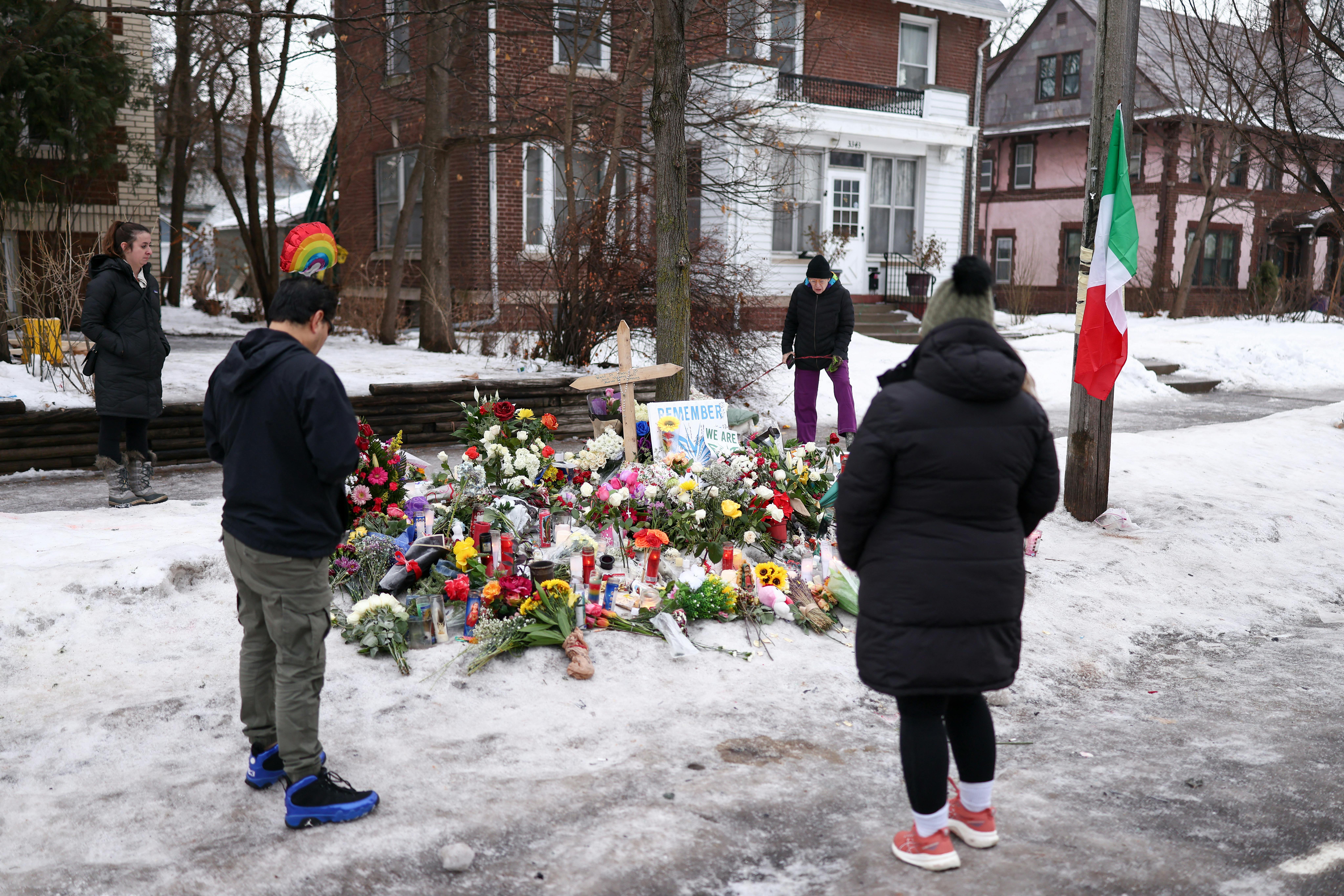 People stand around a memorial for Renee Nicole Good, who was shot dead by an ICE agent in Minneapolis, Minnesota