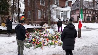 People stand around a memorial for Renee Nicole Good, who was shot dead by an ICE agent in Minneapolis, Minnesota