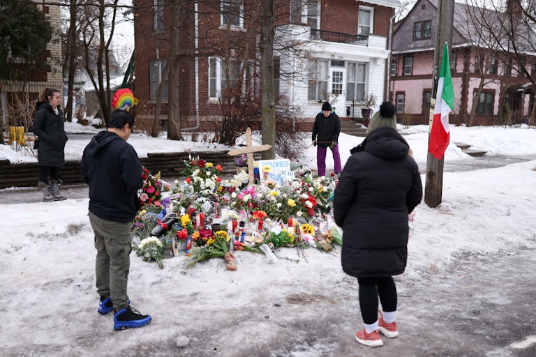 People stand around a memorial for Renee Nicole Good, who was shot dead by an ICE agent in Minneapolis, Minnesota
