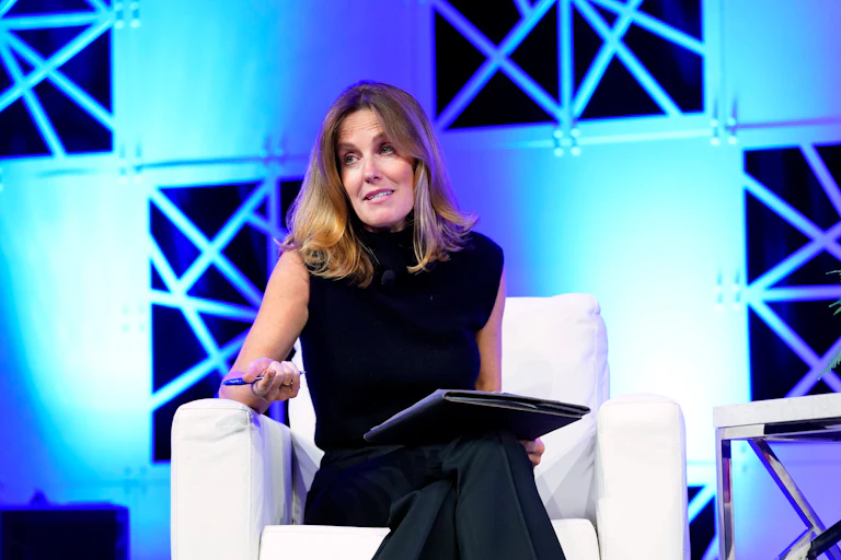 Sharyn Alfonsi speaks while seated on a chair on stage.