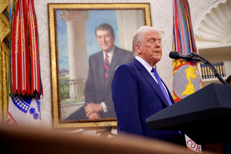 Donald Trump makes a face while speaking at a podium in the Oval Office