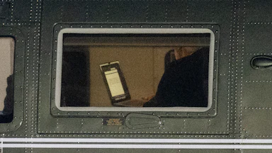 President Donald Trump holds a laptop aboard Marine One