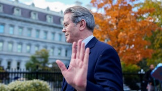 Treasury Secretary Scott Bessent holds his hand up while walking away from reporters outside the White House