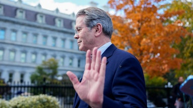 Treasury Secretary Scott Bessent holds his hand up while walking away from reporters outside the White House