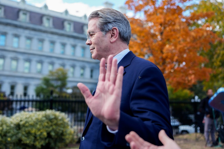 Treasury Secretary Scott Bessent holds his hand up while walking away from reporters outside the White House