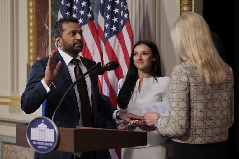 Kash Patel swears in as FBI director while his girlfriend Alexis Wilkins smiles and looks on.