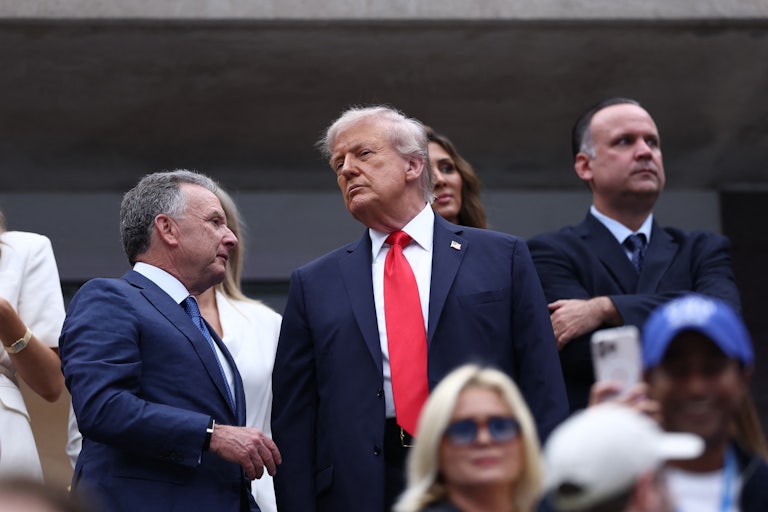 Steve Witkoff says something to Donald Trump as they stand in the crowd at the U.S. Open.