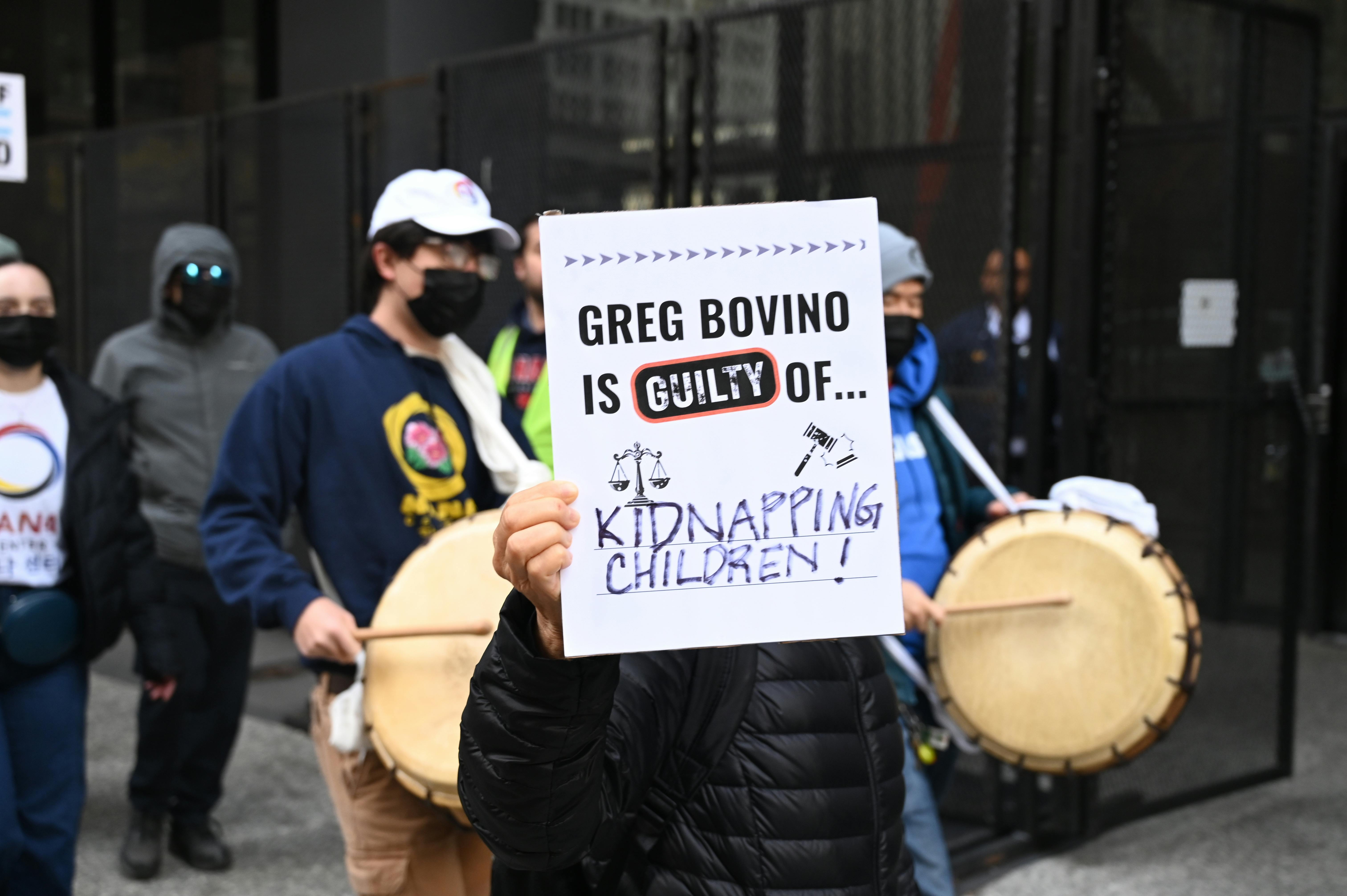 A protester in Chicago holds a sign reading "Greg Bovino Is Guilty Of Kidnapping Children."