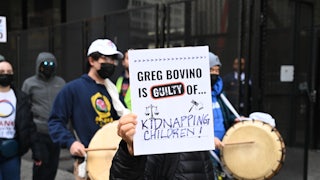 A protester in Chicago holds a sign reading "Greg Bovino Is Guilty Of Kidnapping Children."