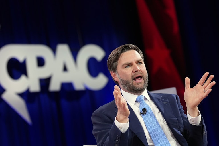 Vice President JD Vance speaks and gestures while sitting onstage at CPAC