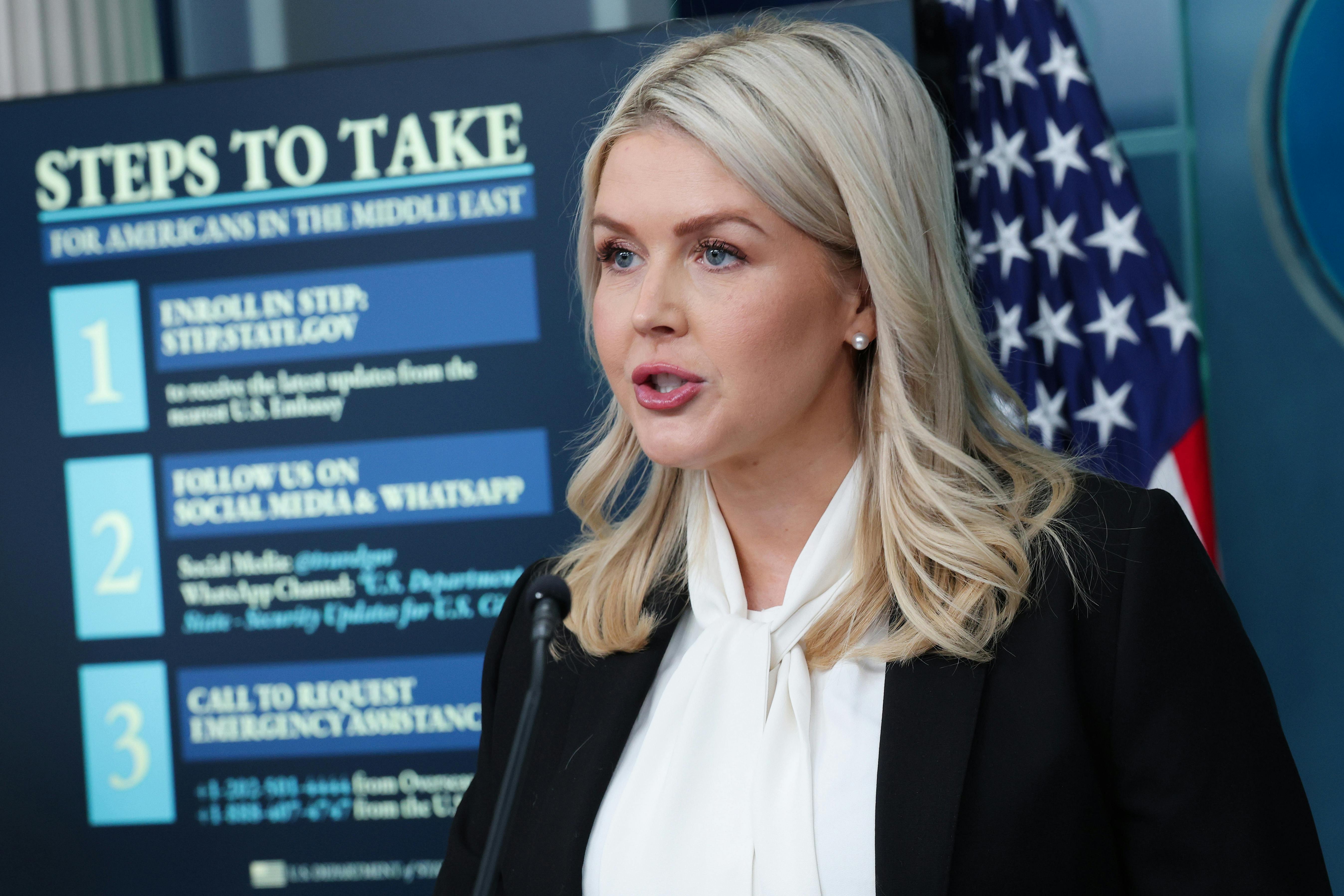 White House press secretary Karoline Leavitt stands in front of a screen that says "Steps to Take for Americans in the Middle East."