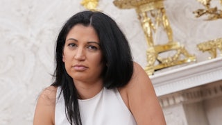 Katie Miller looks unamused while standing in Trump's gold Oval Office.