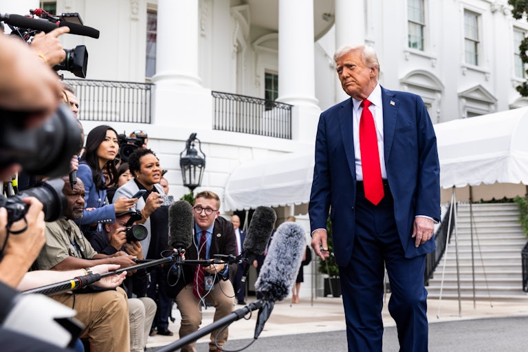 Donald Trump frowns at reporters while standing outside the White House